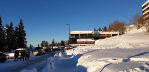 een met sneeuw bedekte straat met een gebouw op de achtergrond bij Appartement 8 personnes 3 chambres 1 750 m altitude in Chamrousse