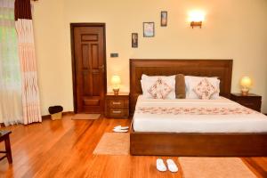 a bedroom with a bed and a wooden floor at Tea Queens Bungalow in Hatton
