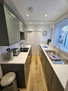 een keuken met een spoelbak en een aanrechtblad bij Pretty City Centre Cottage in Hackington