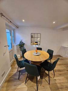 een eetkamer met een houten tafel en stoelen bij Pretty City Centre Cottage in Hackington
