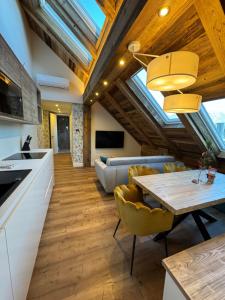 a kitchen and living room with a table and chairs at Vila Urbana Luxury Apartments in Lesce