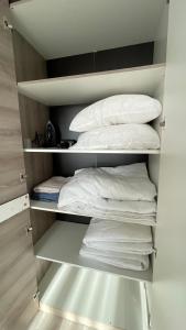 een kast vol witte kussens en handdoeken bij БЦ Алматы, иманова-валиханова in Astana