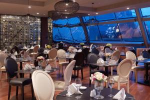 un ristorante con tavoli e sedie e una grande finestra di Pullman Istanbul Hotel & Convention Center a Istanbul