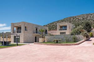 a large brick building with a hill in the background at Elios Estate for large groups in Chania Town +80 photos