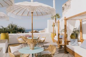 a patio with tables and chairs and an umbrella at Dreamsea Boutique Experience in Moya