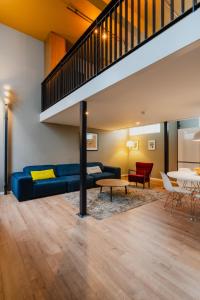 Una sala de estar con un sofá azul y una mesa. en Apartments De Hallen, en Ámsterdam