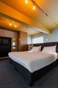 1 dormitorio grande con 1 cama grande con sábanas blancas en Apartments De Hallen, en Ámsterdam