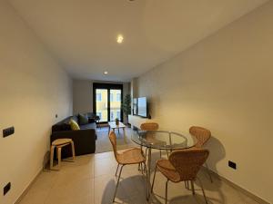 ein Wohnzimmer mit einem Glastisch und Stühlen in der Unterkunft Las Canteras Deluxe in Las Palmas de Gran Canaria