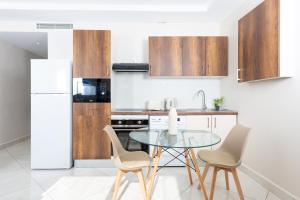 a kitchen with a table and chairs and a refrigerator at Magnifique 2 pièces rénové aux Sources in Vieux Kouba