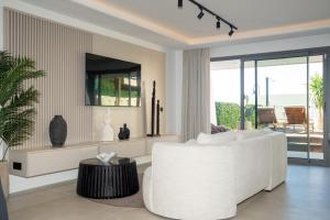 a living room with a white couch and a table at Beautiful Modern Town House - EDEN RESORT in Mijas Costa