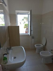un bagno con lavandino, WC e finestra di Villa Amalia - condominium private beach a San Felice Circeo Altre 34 foto