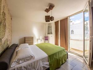 Un dormitorio con una cama y una ventana grande. en Martine Dimore Storiche di Puglia, en Martina Franca