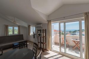 a living room with a table and a view of a balcony at Apartments Mazuran in Hvar
