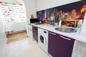 a kitchen with a sink and a washing machine at Panorama Suite in Galaţi