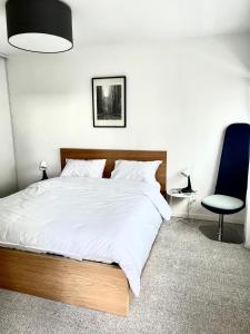 una camera da letto con un letto grande e una sedia blu di T2 avec Parking, 7min Paris & Stade France a Saint-Denis Altre 3 foto