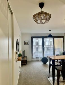 un soggiorno con un tavolo e una sala da pranzo di T2 avec Parking, 7min Paris & Stade France a Saint-Denis