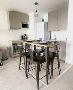 una cucina con un tavolo e sedie in una stanza di T2 avec Parking, 7min Paris & Stade France a Saint-Denis