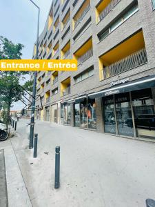 un cartello stradale di fronte a un edificio di T2 avec Parking, 7min Paris & Stade France a Saint-Denis
