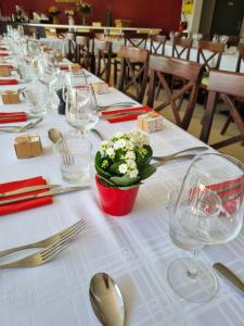 a long table with wine glasses and flowers on it at Au Périgord Noir in Hautefort