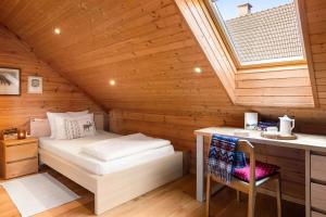 a bedroom in a wooden cabin with a bed and a desk at Wellness Chalet close to Ljubljana in Rakitna