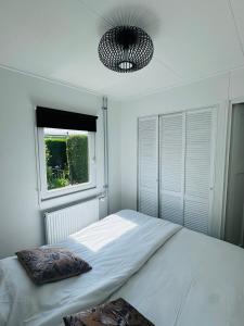 une chambre avec un grand lit et une fenêtre dans l'établissement Familie Vakantiehuis - Zonneweelde, à Noordwijk aan Zee