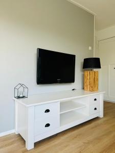 un centre de divertissement blanc avec une télévision à écran plat sur un mur dans l'établissement Familie Vakantiehuis - Zonneweelde, à Noordwijk aan Zee