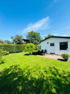 une arrière-cour avec une maison blanche et une pelouse dans l'établissement Familie Vakantiehuis - Zonneweelde, à Noordwijk aan Zee