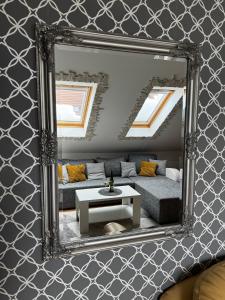 espejo en la pared con sofá y mesa en Apartment Meri in Kraljevi Cardaci, en Kopaonik