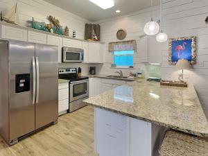 a kitchen with stainless steel appliances and white cabinets at Jamaica Me Happy in Port Aransas