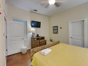 a bedroom with a bed with a yellow bedspread at Jamaica Me Happy in Port Aransas