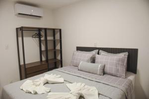 a bedroom with a bed with towels on it at GUARAJUBA TIE 4 Quartos DUPLEX DE LUXO in Camacari