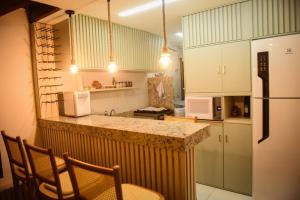 a kitchen with a counter and a refrigerator at GUARAJUBA TIE 4 Quartos DUPLEX DE LUXO in Camacari