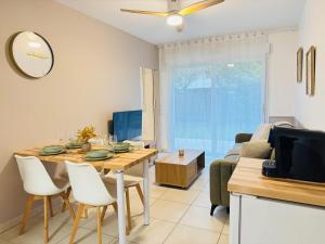 a kitchen and living room with a table and a tv at L'Ecrin Douceur - Parking privée & Proche gare in Sainte-Savine