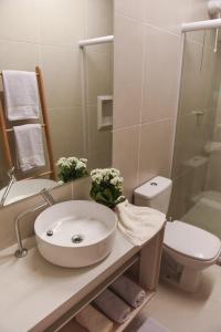 a bathroom with a sink and a toilet and a shower at GUARAJUBA TIE 4 Quartos DUPLEX DE LUXO in Camacari