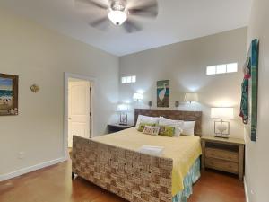 a bedroom with a large bed and a ceiling fan at Jamaica Me Happy in Port Aransas