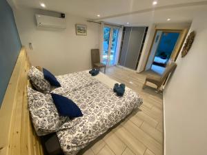 a bedroom with a bed with blue pillows at Ti case fleur letchi - cadre calme et agréable, 15 min des plages in Les Avirons