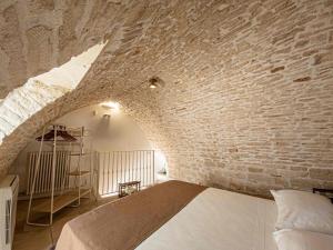 a bedroom with a bed in a brick wall at Martine Dimore Storiche di Puglia in Martina Franca