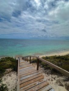 a wooden pathway to the beach with the ocean at Breeze Brae Home in Grand Turk