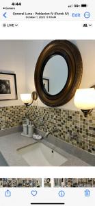 a bathroom with a large mirror and a sink at Dajon-2 Exec Suite in General Luna