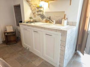 a kitchen with white cabinets and a counter top at Martine Dimore Storiche di Puglia in Martina Franca