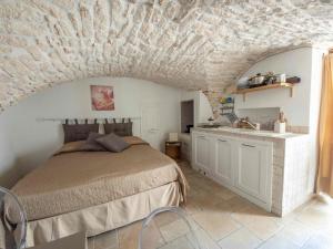 a bedroom with a bed and a stone wall at Martine Dimore Storiche di Puglia in Martina Franca