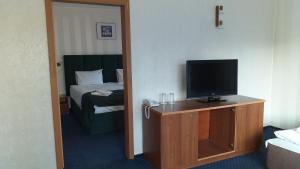 Una habitación de hotel con televisión y cama. en Finlandia Hotel, en Pamporovo