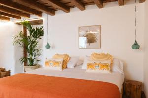 a bedroom with a bed with orange and white pillows at Dreamsea Boutique Experience in Moya