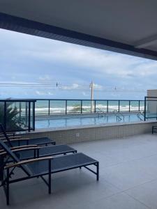 una vista dell'oceano da un edificio con panchine di Apartamento Beira-mar orla sul a Ilhéus
