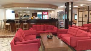 una sala de estar con sillas rojas y un bar en Finlandia Hotel, en Pamporovo