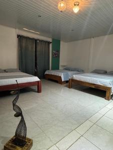 a room with two beds and a statue in it at Casa Leona in Quepos