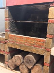 a stack of logs in a brick oven at Casa Leona in Quepos +2 photos