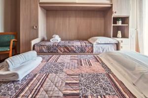 a bedroom with two beds with a rug on the floor at Firenze Bellariva Riverside Stay in Florence