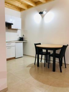 Una cocina con una mesa y sillas en una habitación. en Maison du Château Sarre, en Aosta