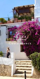 ein Gebäude mit lila Blumen auf der Seite in der Unterkunft Beach LUXURY - ALTEA Puerto de Campomanes in Altea